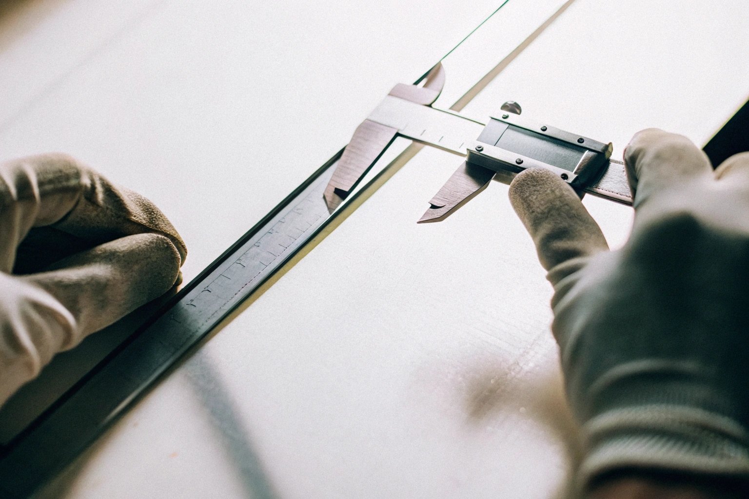 Worker measuring tin plate coil with calipers